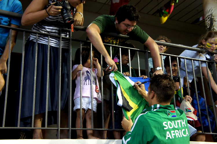 Chad autographs the South African flag of his fellow countryman