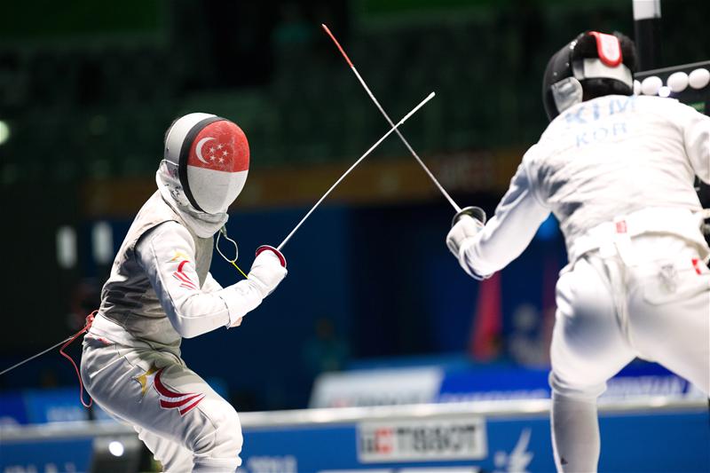 Jerrold Chan (left), who came on as a substitute for Joshua Lim, was the only one of Singapore's four fencers to outscore his opponent. He managed seven touches to Kim's five to draw the score to 35–18 in the seventh of nine duels. (Photo courtesy of Sport Singapore via Action Images Livepic) 