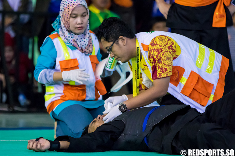 Medical staff attend to Ahmad Rashideen of Singapore during the 17th ASEAN University Games Pencak Silat Championships. Rashideen took a direct kick to his face from Malaysia's Mohd Khaizul Yaacob in the men's class H semi-final, which warranted a possible disqualification but was not called by the referee. Rashideen had to bow out of the semi-final. (Photo 42 © Lim Yong Teck/Red Sports)
