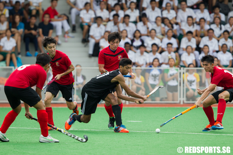 Assad Khalique (#21) of Raffles Institution goes against four Anglo-Chinese Junior College defenders. (Photo © Lee Jian Wei/Red Sports)