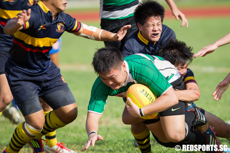 Scott Tan (#12) and Nickolas Tan (#2) of Anglo-Chinese Junior College tackle Keith Tay (#1) of Raffles Institution. (Photo © Lee Jian Wei/Red Sports)