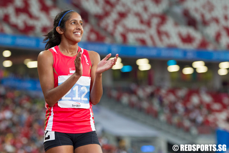 Veronica Shanti Pereira (#212) smiles as she watches the replay of her 100m sprint. (Photo © Lee Jian Wei/Red Sports)