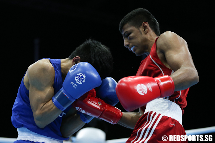 Hanurdeen Hamid (Red) of Singapore does throws a uppercut to Ian Clark Bautista (Blue) of Philippines. (Photo © Lee Jian Wei/Red Sports)
