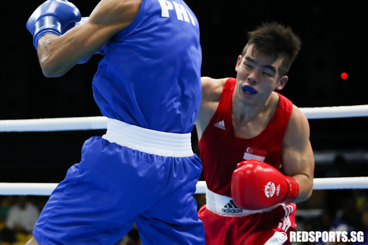 Tay Jia Wei (Red) of Singapore throws a punch at Eumir Felix Marcial (Blue) of Philippines. (Photo © Lee Jian Wei/Red Sports)