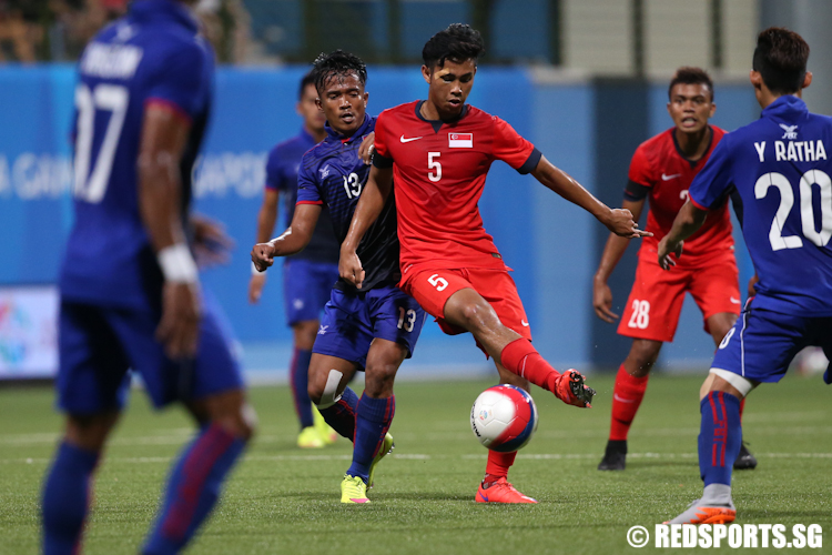 Adamn Swandi (#5) of Singapore controls the ball against Ol Ravy (#13) of Cambodia. (Photo © Lee Jian Wei/Red Sports)