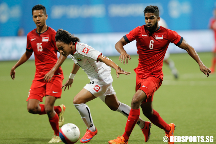 Naing Kuang Sat (#9) of Myanmar dribbles the ball against Anumanthan Kumar (#6) of Singapore. (Photo © Lee Jian Wei/Red Sports)
