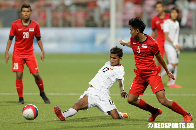 Zin Lwin Kyaw (#12) of Myanmar tackles the ball away from Adamn Swandi (#5) of Singapore. (Photo © Lee Jian Wei/Red Sports)