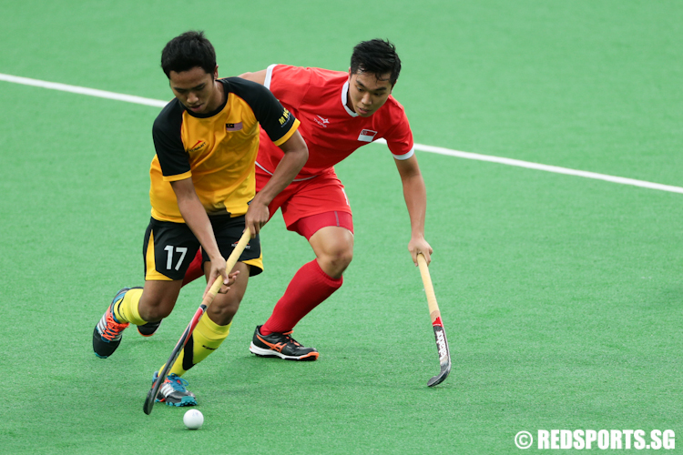 Timothy Goh (#13) of Singapore and Rafizul Ezry Mustafa (#17) of Malaysia fight for possession of the ball. (Photo © Lee Jian Wei/Red Sports)