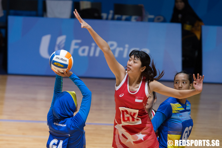 Chen Li Li (GK) of Singapore jumps to block Izyan Syazana (GA) of Malaysia. (Photo © Lee Jian Wei/Red Sports)
