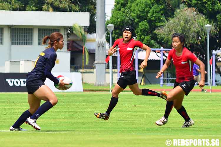 Thailand's Yusri Chitchanok attempts to get the ball past Singapore's Lee Yi Tian (L) and Christabelle Lim (R).(Photo © Rebekah Abbott/Red Sports) 
