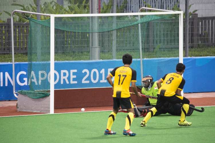 Malaysia draw first blood from a penalty corner. Aiman Nik Rozemi (#8) is the scorer. 