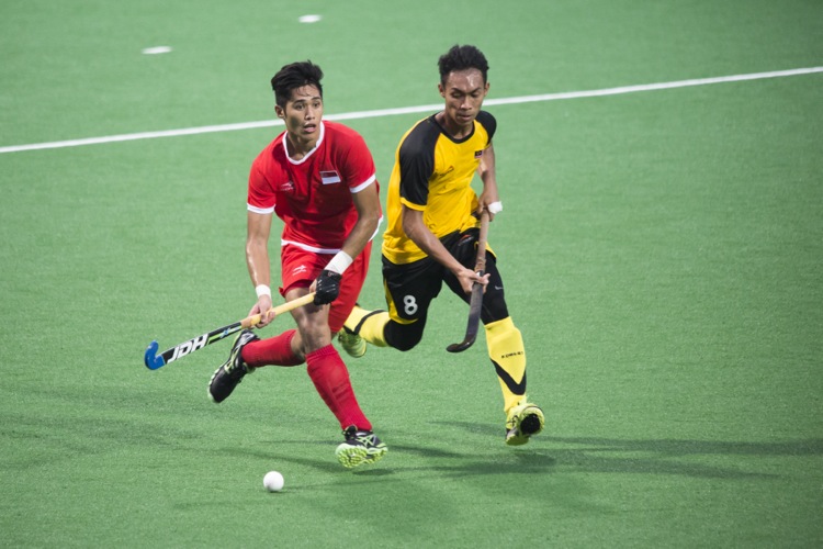 Battle of the midfielders, Singapore’s Zulkepli (#11) and Aiman Nik Rozemi (#8) of Malaysia.