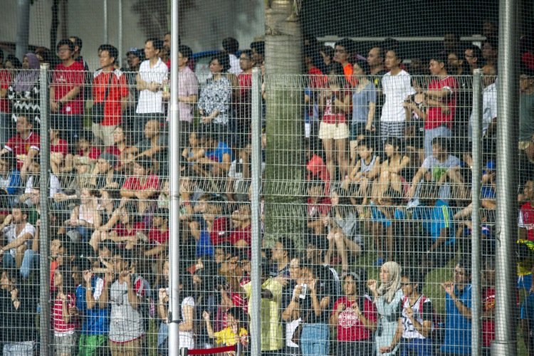 The Hockey Stadium in Sengkang is beyond full capacity as many take their seats on the steps of the stadium and many more sit on embankment outside the grounds.
