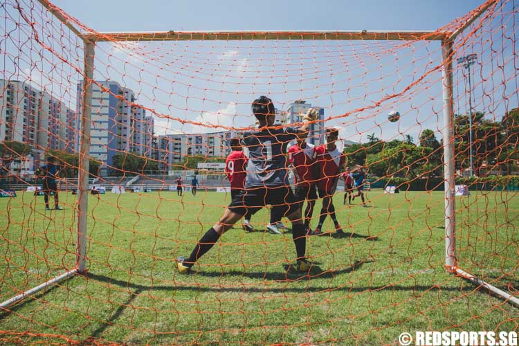 A goalkeeper tries to save a shot attempt after a corner kick was awarded to the opposing team. (Photo 12 © Soh Jun Wei/Red Sports)