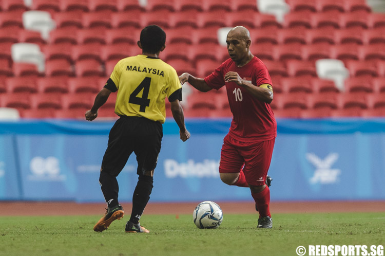 Khairul Anwar Bin Kasmani (SIN #10) dribbles the ball against his Malaysian defender, Hamdan Bin Koderi (MAS #4) (Photo 4 © Soh Jun Wei/Red Sports)