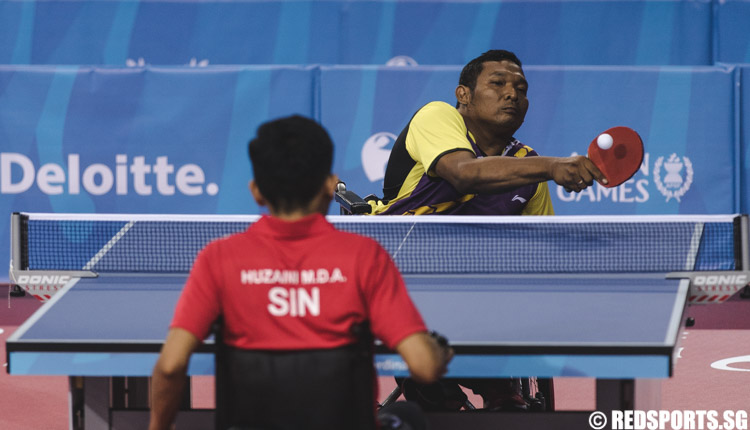 Cahyo Pambudi (INA) volleys the ball aginst Muhammad Dinie Asyraf Bin Huzaini (SIN) during the Men's Team Table Tennis Round 1 Match 2 of the 8th ASEAN Para Games. (Photo 2 © Soh Jun Wei/Red Sports)