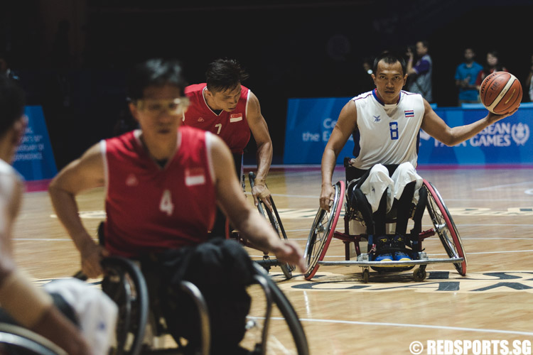 Surasit Nirat (THA #8) dribbles the ball down the court against Choo Poh Choon (SIN #7) during the wheelchair basketball game at the 8th ASEAN Para Games. (Photo 5 © Soh Jun Wei/Red Sports)