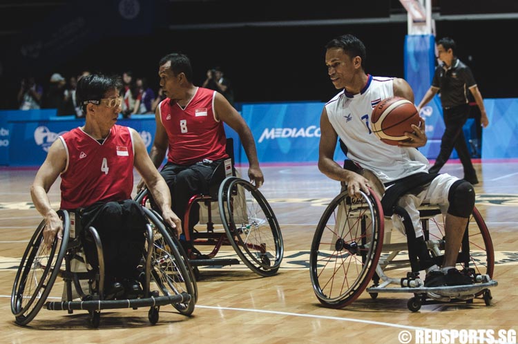 Visut Sukon (THA #7) controls the ball against Khoo Seng Wah (SIN #4) during the wheelchair basketball game at the 8th ASEAN Para Games. (Photo 6 © Soh Jun Wei/Red Sports)
