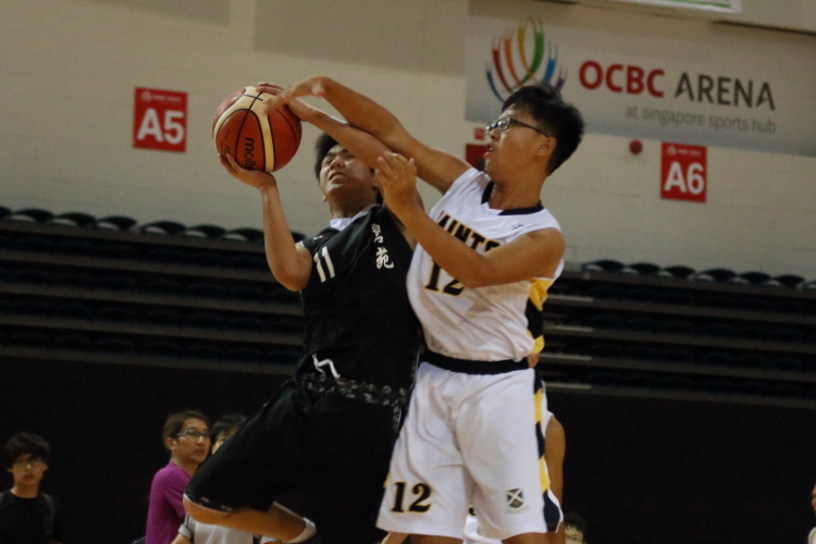 Lim Shi Zuo (BPS #11) having his layup heavily contested by #12 of SAS.