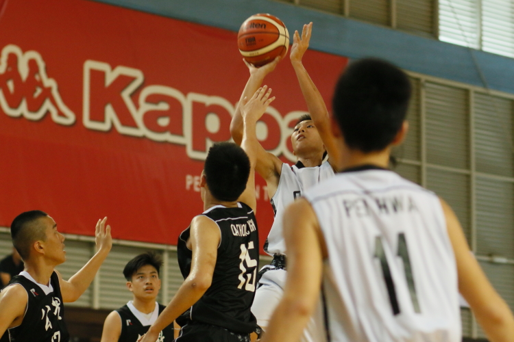 A Pei Hwa player rises for a jumpshot over the Catholic High defense.