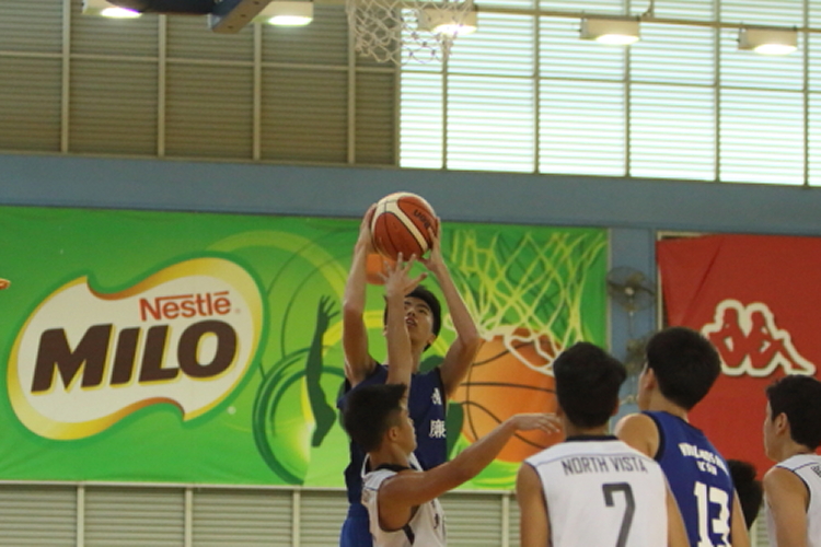 Cai Jiajian(Blue #10) of Woodlands Ring attempting a layup over the his defender.