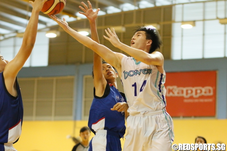 Wilbur Tan Ming Sheng (Bowen #14) finds himself heavily contested as he attempts a layup. He finished with 17 points in the victory. (Photo  © Chan Hua Zheng/Red Sports)