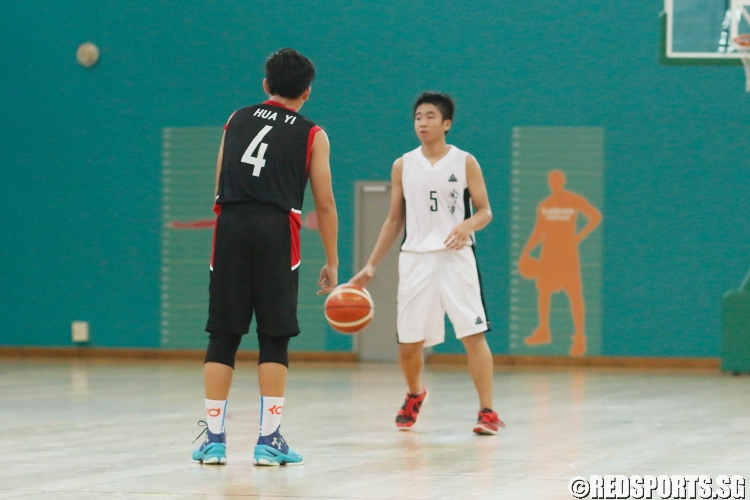 Lenson Lim (Nan Hua #5) surveys the Hua Yi defense for an opening. He scored a team-high 9 points in the game. (Photo  © Chan Hua Zheng/Red Sports)