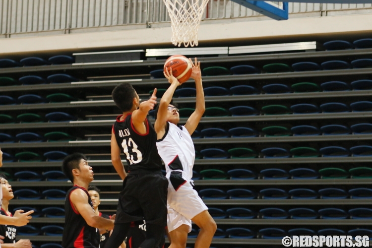 Queenstown's #14 goes up strong for an underbasket shot against his defender. (Photo  © Chan Hua Zheng/Red Sports)