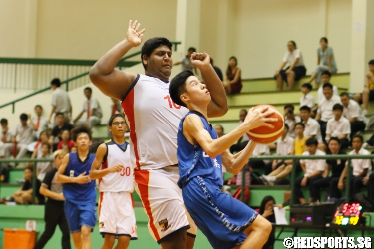Kenneth Tan Yi Yang (YYS #5) goes up for a layup on a fast break as Lavin Raj (ACSB #10) lurks closely behind. (Photo  © Chan Hua Zheng/Red Sports) 