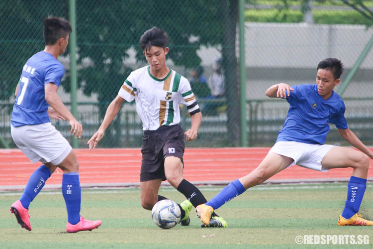Astenn Mun (SRJC #10) dribbles the ball under pressure from Dunman High players. (Photo © Chua Kai Yun/Red Sports)