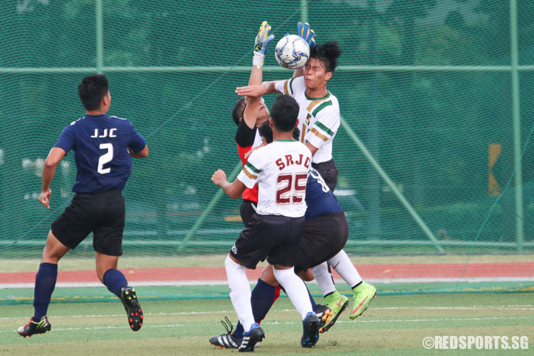 Jove Liew (SRJC #21) collides against JJC's goalkeeper, allowing Syafiq (SRJC #25) to score a goal. (Photo © Chua Kai Yun/Red Sports)