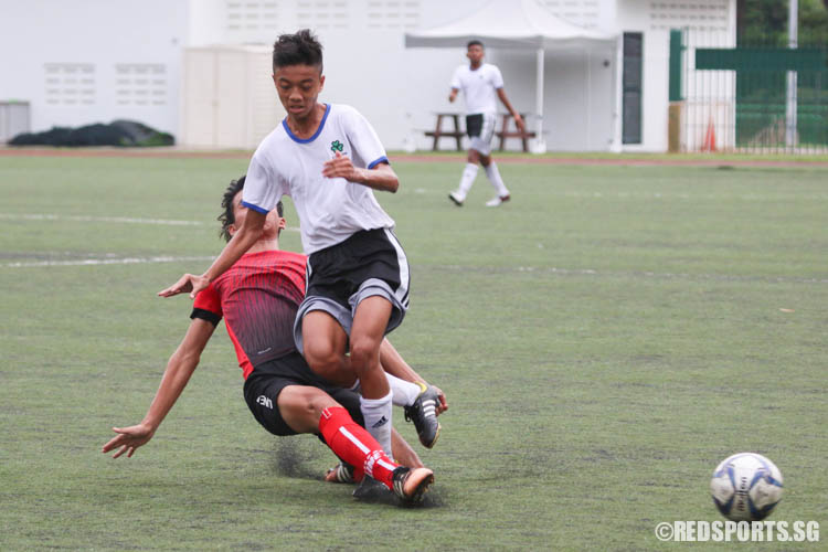 Richian Joshua O Sapitan (St. Patrick's #13) gets tackled by Simon Pun (Bendeneer #5). (Photo © Chua Kai Yun/Red Sports)