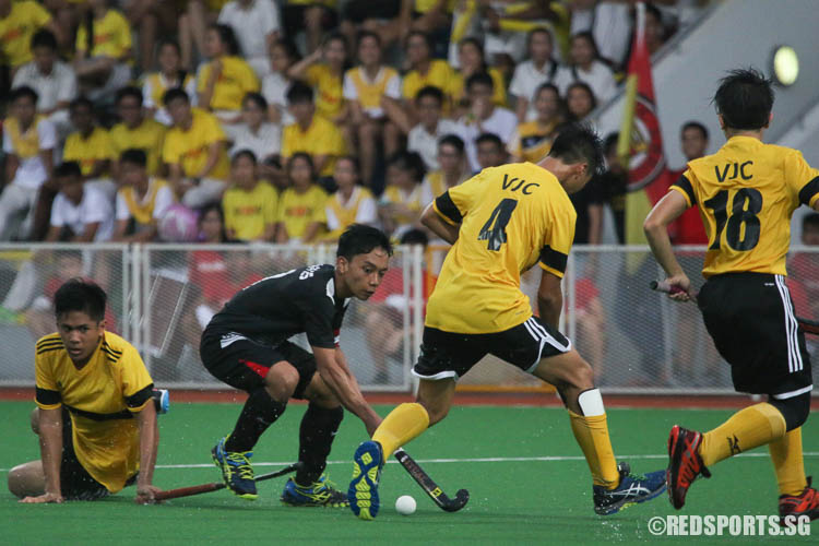 Adam Aniq (#7) of RI hits the ball against VJC defenders. (Photo © Chua Kai Yun/Red Sports)