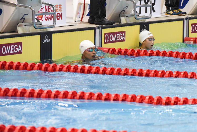 Nurul Fajar Fitriati of Indonesia (left) looking at the scoreboard after finishing second while third placed Elizabeth Khoo (right) looks on during the Women's 200m Backstroke final on the third day of the 13th Singapore National Swimming Championship. (Photo © Stefanus Ian/Red Sports)