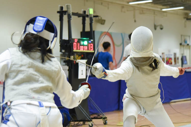 Kemei Cheung of Absolute Fencing attacking Natalia Yau-Cortes of YMCA in the final bout of the under-14 individual girls' foil. (Photo © Jeremy Ho/Red Sports)