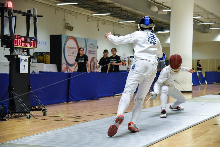 Simon Lee of Singapore Sports School scoring the equalising touch in the final bout of the boys' individual epee category on the final day of the fencing competition at the Singapore Youth Olympics Festival. (Photo © Jeremy Ho/Red Sports)