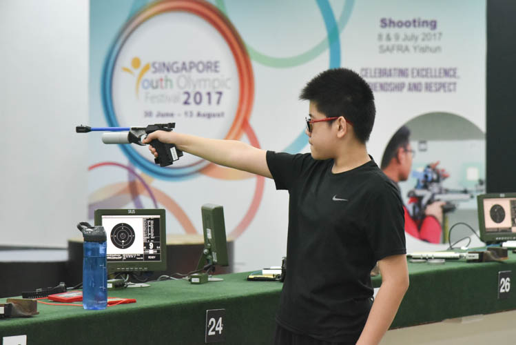 Hang Zizhou of St Hilda's Primary School shooting during the Air Pistol Men's Y13 category competition, he came in second with a score of 506. (Photo ©  Stefanus Ian/Red Sports)