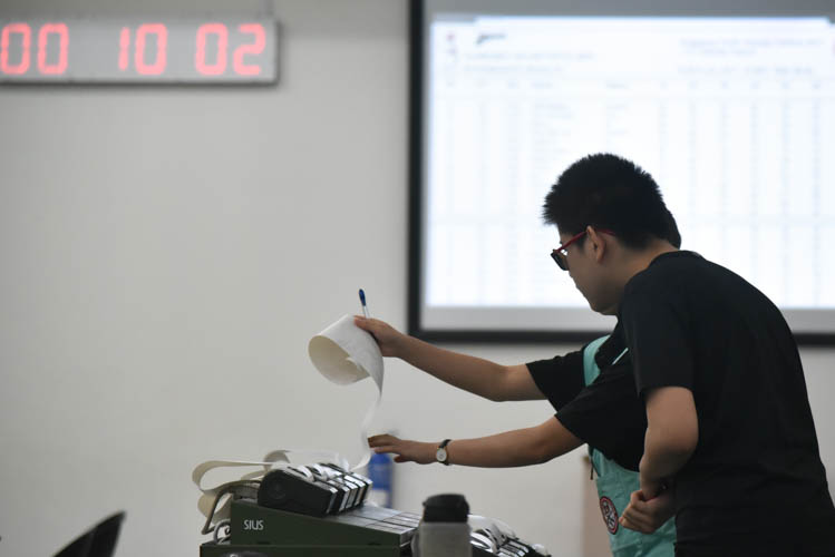 Hang Zizhou of St Hilda's Primary School checking his scores after the tournament during the Air Pistol Men's Y13 category competition, he came in second with a score of 506. (Photo ©  Stefanus Ian/Red Sports)