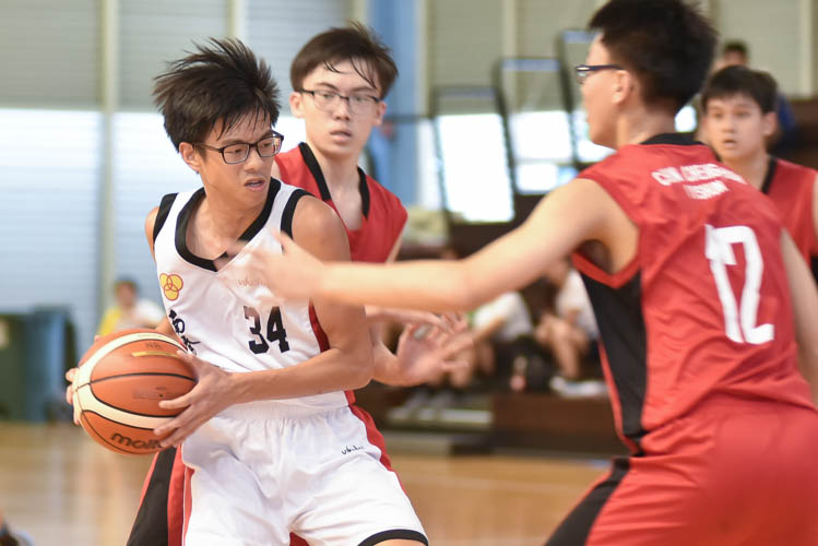 Keane Liew (NCH #34) guarding the ball under tight defence from Lin Rubin (CCHY #12) during the North Zone B Division basketball match between Chung Cheng High and Nan Chiau High School. (Photo © Stefanus Ian/Red Sports)