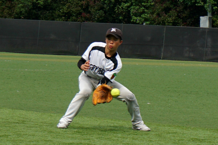 Yi Fan (RI #09) in action while the ball narrowly tips off his glove. (Photo 12 © REDintern Pang Chin Yee.)
