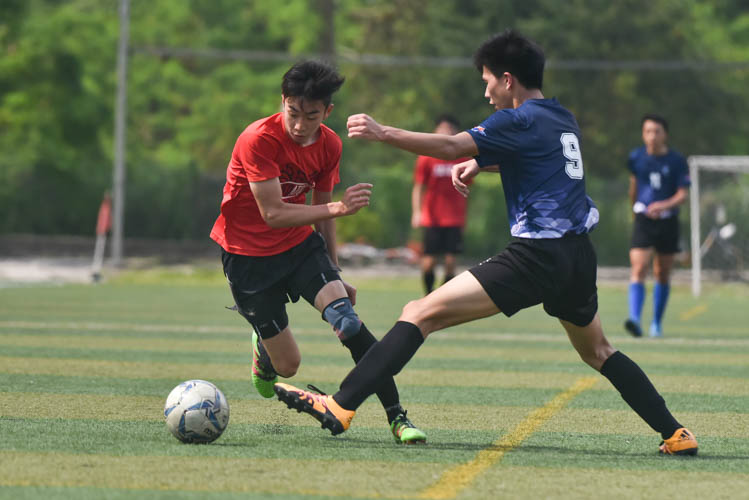 A Raffles Institution player (in red) dribbling the ball down the wings during a NYSI JC League match between Raffles Institution and River Valley High School. (Photo © Stefanus Ian/Red Sports)