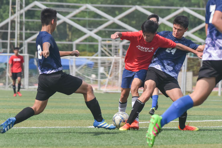 A Raffles Institution player (in red) guarding the ball inside the penalty box during a NYSI JC League match between Raffles Institution and River Valley High School. (Photo © Stefanus Ian/Red Sports)