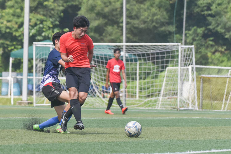 Raffles Institution's Edmund Zhang (in red) taking a shot during a NYSI JC League match between Raffles Institution and River Valley High School. (Photo © Stefanus Ian/Red Sports)