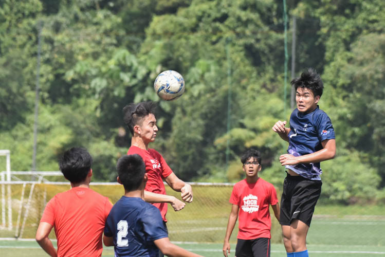A Raffles Institution player (in red) making a free header during a NYSI JC League match between Raffles Institution and River Valley High School. (Photo © Stefanus Ian/Red Sports)