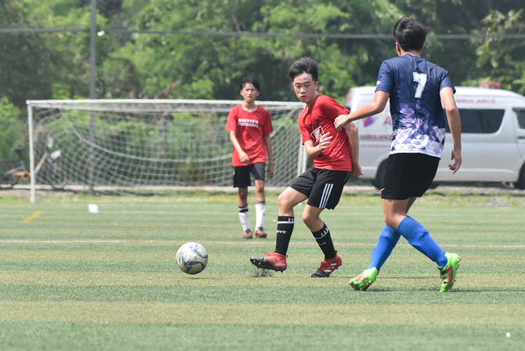 A Raffles Institution player (in red) passing the ball during a NYSI JC League match between Raffles Institution and River Valley High School. (Photo © Stefanus Ian/Red Sports)