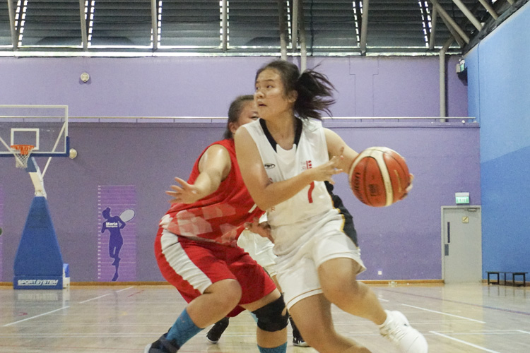 Valerie (JSS #7) drives against Hong Xinning (RVHS #7) during the West zone B division basketball match between Jurong Secondary School and River Valley High School. (Photo 7 © Pang Chin Yee/REDintern)