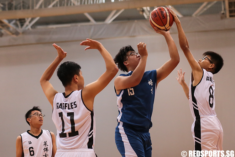 (#8) of Raffles Institution deflects the shot made by Stallonzo Lee (#15) of Pei Cai Secondary. (Photo 4 © Lee Jian Wei/Red Sports)
