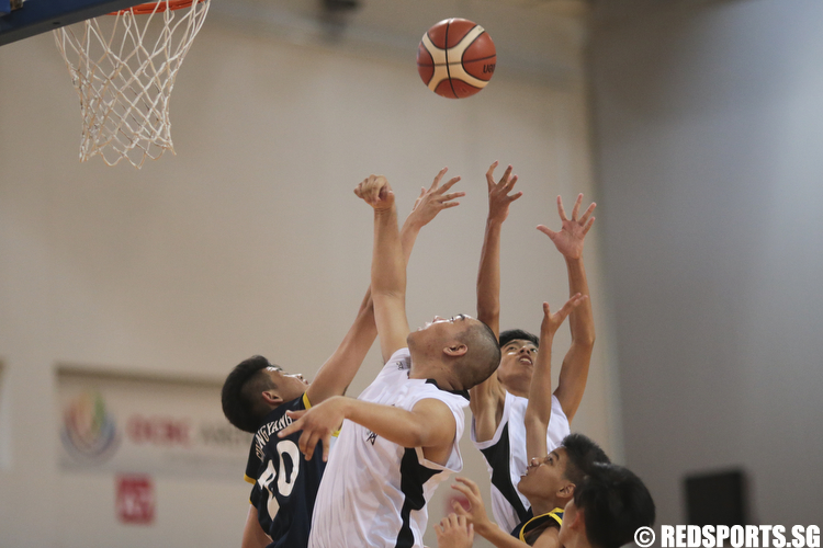 Jespar Parulan (#15) and Moses Peh (#11) of Dunman Secondary fights for the rebound against Nicholas Chua (#20) of Guang Yang Secondary. (Photo © Lee Jian Wei/Red Sports)