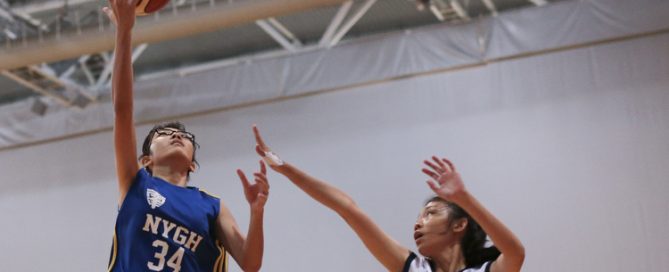 Emi Chow (#34) of Nanyang Girls shoots a layup against Janelle Lim (#8) of Guang Yang Secondary. (Photo © Lee Jian Wei/Red Sports)