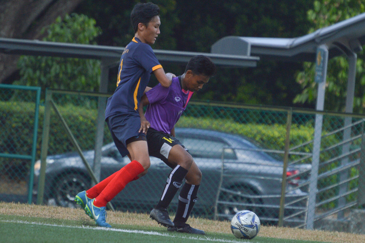 Muhd Heizikal (NLS #14) shields the ball from the ACS(I) player. (Photo 13 © REDintern Nathiyaah Sakthimogan)
